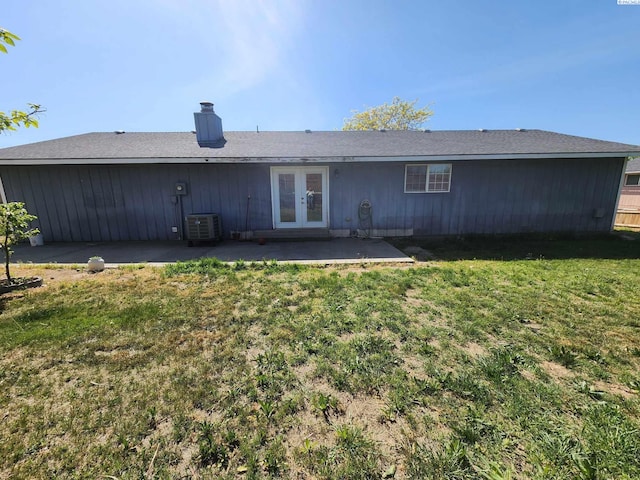 1106 Claire St, Prosser, WA 99350 - back of property featuring central AC, french doors, a chimney, a patio area, and a lawn