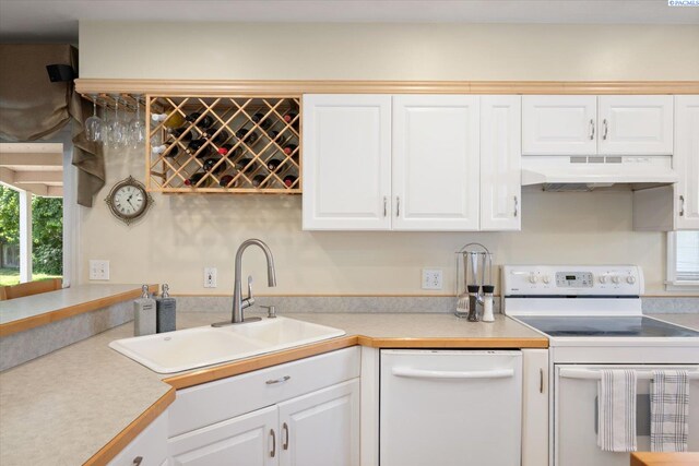 3916 S Date St, Kennewick, WA 99337 - kitchen with white appliances, under cabinet range hood, white cabinets, and light countertops