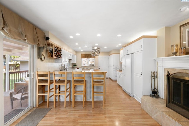 3916 S Date St, Kennewick, WA 99337 - kitchen with white refrigerator with ice dispenser, a peninsula, light wood-type flooring, white cabinetry, and recessed lighting