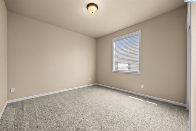 carpeted spare room featuring baseboards