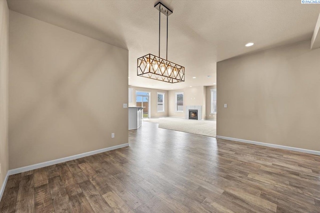 unfurnished living room with baseboards, recessed lighting, and wood finished floors