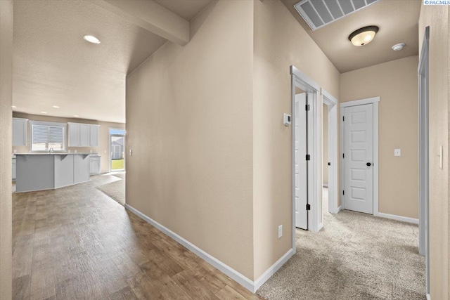 hallway with recessed lighting, baseboards, light wood finished floors, and visible vents