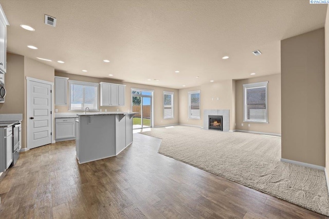kitchen with visible vents, stainless steel range with electric stovetop, baseboards, light wood-style floors, and a kitchen breakfast bar