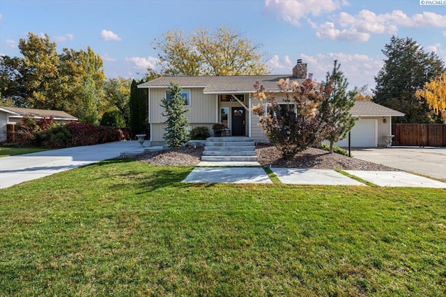 bi-level home featuring a garage and a front lawn