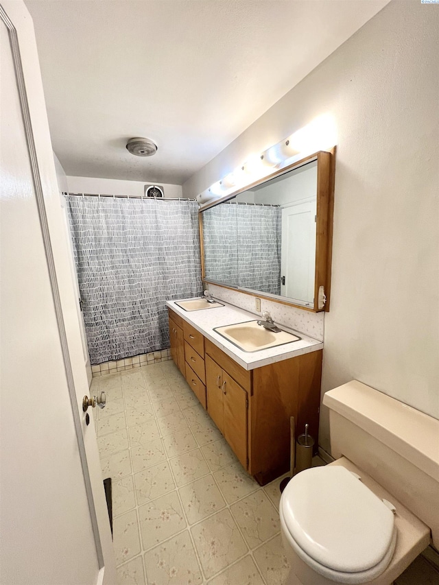 bathroom with toilet, vanity, and curtained shower