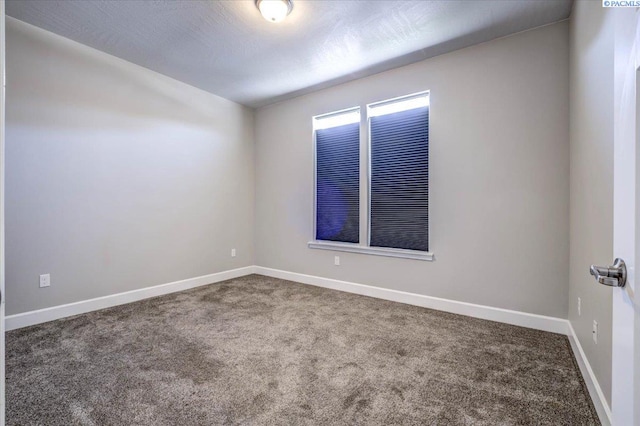 empty room featuring baseboards and carpet flooring