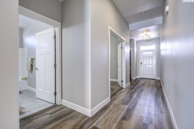 hallway featuring baseboards and wood finished floors