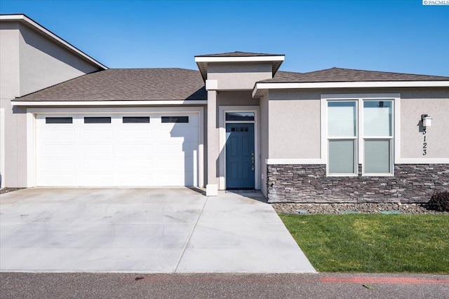 prairie-style home featuring concrete driveway, a garage, stone siding, and stucco siding