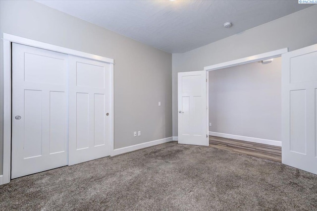 unfurnished bedroom featuring baseboards, carpet, and a closet