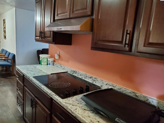 kitchen with cooktop, dark hardwood / wood-style flooring, black electric stovetop, and dark brown cabinetry