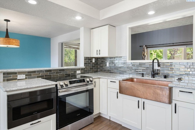 kitchen with backsplash, appliances with stainless steel finishes, plenty of natural light, and a sink