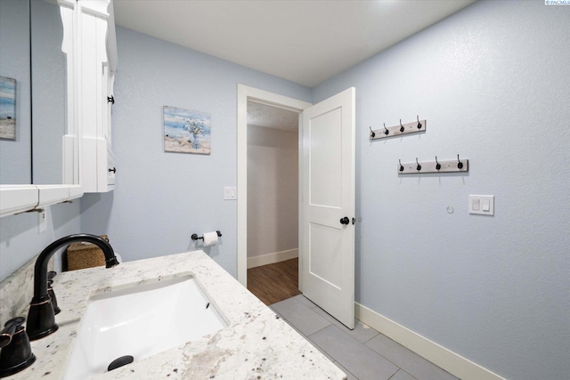 bathroom with baseboards, a sink, and tile patterned floors