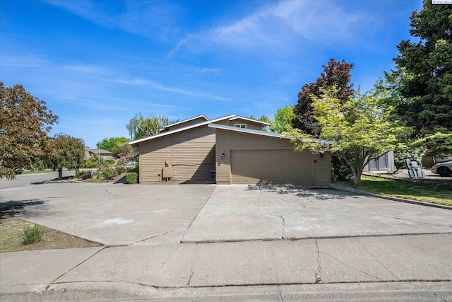 view of side of home with a garage and driveway
