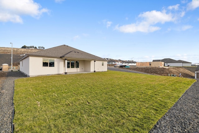 6531 W 30th Pl, Kennewick, WA 99338 - rear view of property with stucco siding, a lawn, and roof with shingles