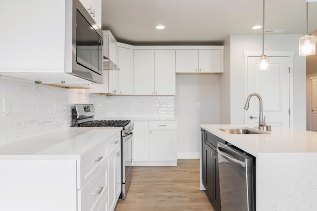 6531 W 30th Pl, Kennewick, WA 99338 - kitchen featuring stainless steel appliances, light wood-style flooring, backsplash, white cabinetry, and pendant lighting