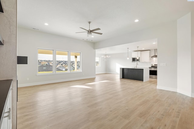 6531 W 30th Pl, Kennewick, WA 99338 - unfurnished living room featuring a ceiling fan, a chandelier, recessed lighting, and light wood-style floors