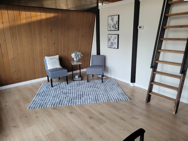 sitting room featuring wooden walls and light wood-type flooring