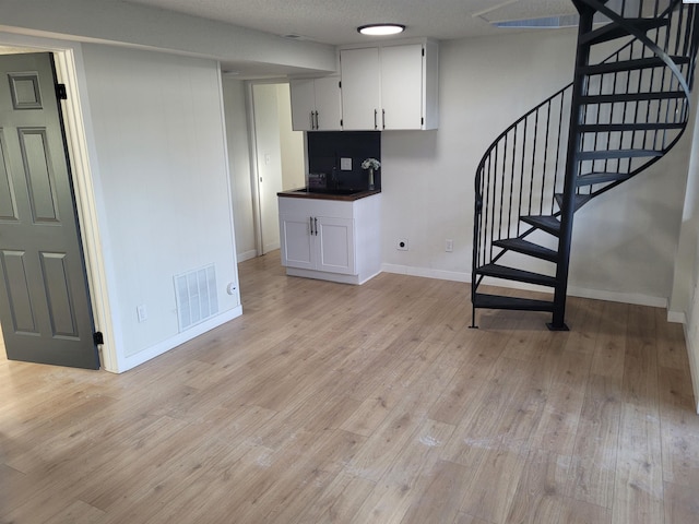 interior space featuring hardwood / wood-style flooring, sink, and a textured ceiling