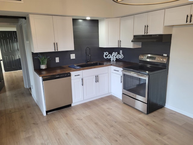 kitchen with sink, butcher block countertops, white cabinetry, stainless steel appliances, and light hardwood / wood-style floors