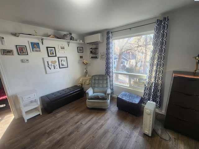 living area featuring wood finished floors and a wall mounted AC