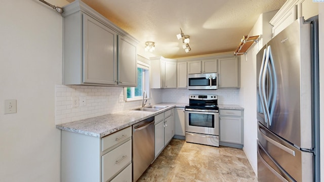 1625 NW Valhalla Dr, Pullman, WA 99163 - kitchen featuring appliances with stainless steel finishes, a sink, backsplash, gray cabinetry, and light stone counters