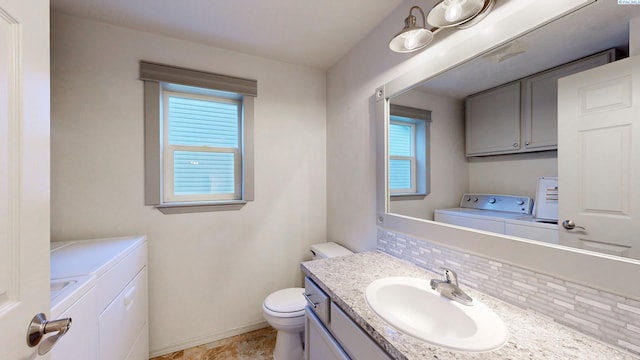 1625 NW Valhalla Dr, Pullman, WA 99163 - bathroom with separate washer and dryer, toilet, vanity, and tasteful backsplash