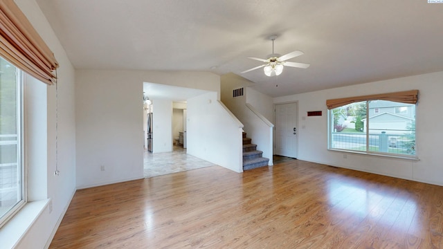 1625 NW Valhalla Dr, Pullman, WA 99163 - unfurnished living room featuring wood finished floors, ceiling fan, stairway, and lofted ceiling