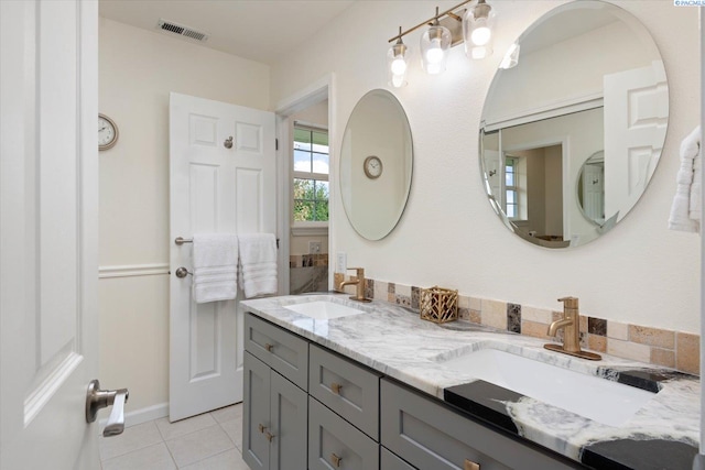 bathroom with tile patterned floors, visible vents, a sink, and double vanity