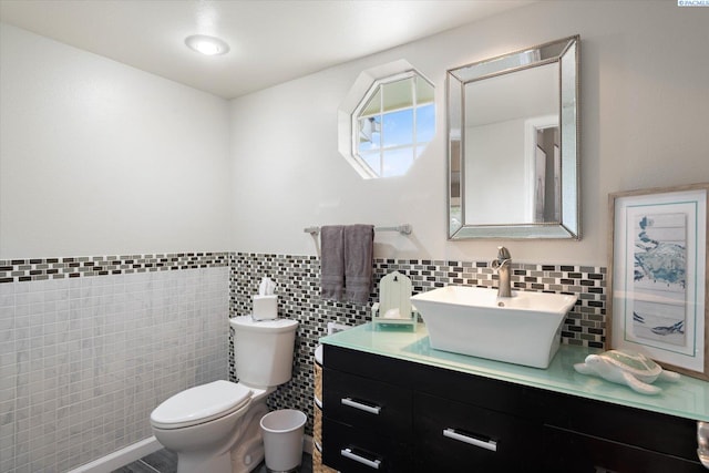 half bath featuring toilet, tile walls, and vanity