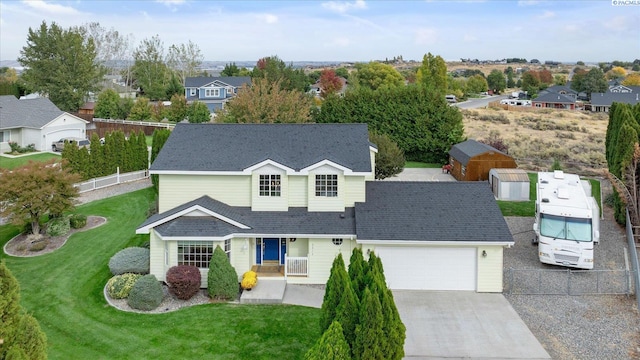 traditional home with a garage, fence, driveway, roof with shingles, and a residential view