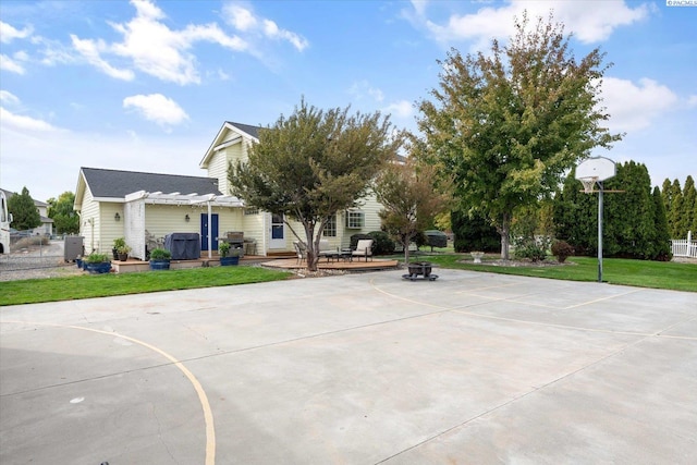 view of sport court featuring basketball court, a yard, fence, and a pergola