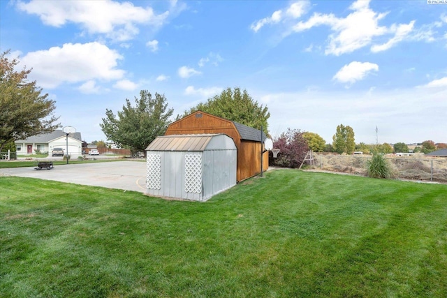 view of yard with a storage shed, fence, and an outbuilding