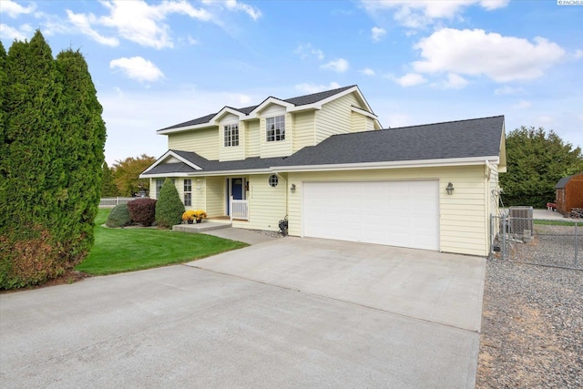 traditional-style house with a garage, driveway, fence, cooling unit, and a front lawn