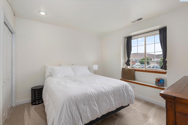 bedroom with light colored carpet, visible vents, and baseboards