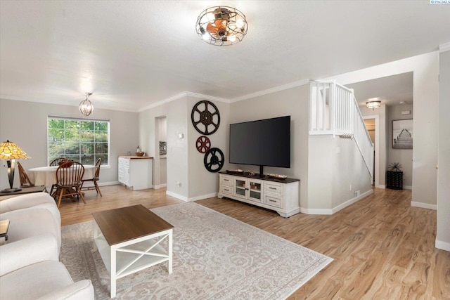 living room featuring light wood-type flooring, baseboards, and crown molding