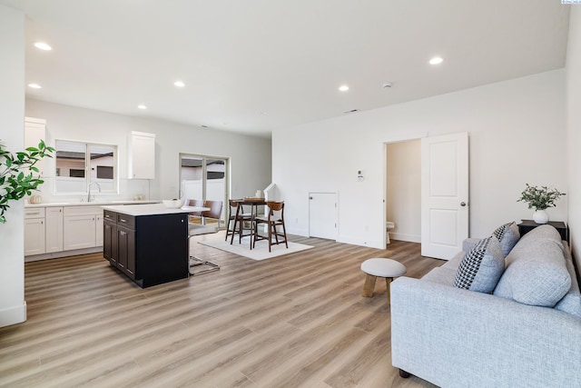 living room with recessed lighting, light wood finished floors, and baseboards