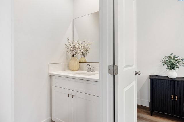 bathroom featuring vanity, baseboards, and wood finished floors