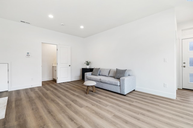 living area with recessed lighting, baseboards, light wood finished floors, and visible vents