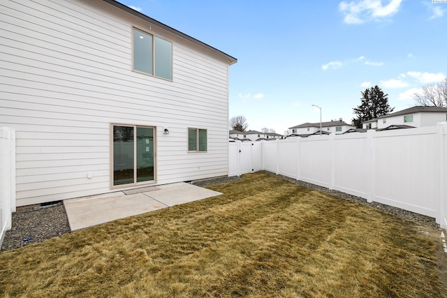 back of property featuring a fenced backyard, a patio, and a yard
