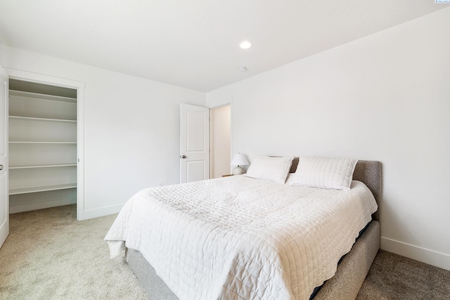 bedroom with carpet flooring, baseboards, and a spacious closet