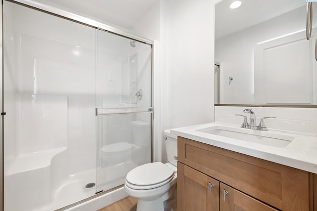 full bathroom with vanity, toilet, recessed lighting, wood finished floors, and a stall shower