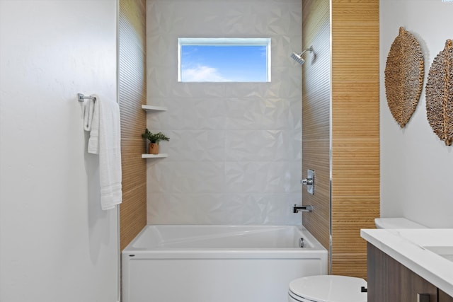 full bathroom with tiled shower / bath, vanity, and toilet