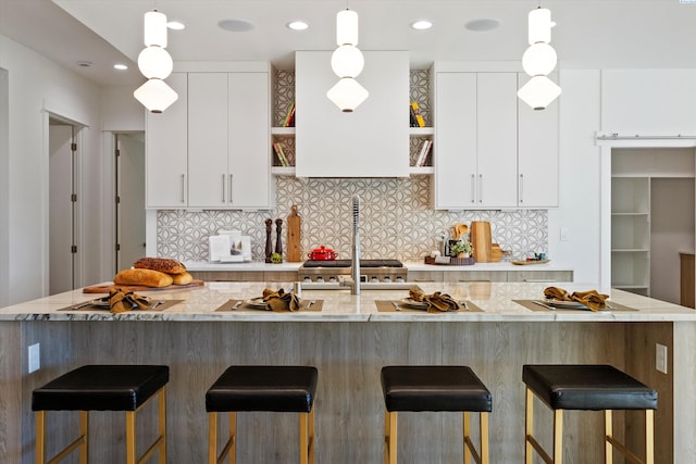 kitchen featuring white cabinetry, pendant lighting, and exhaust hood