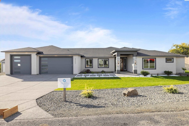 prairie-style house featuring a garage and a front yard