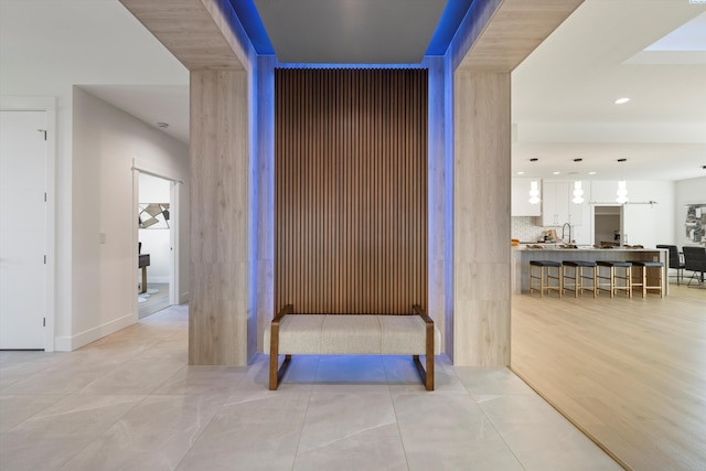 corridor with sink and light tile patterned floors