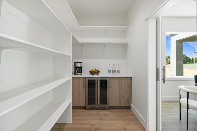 bar with hardwood / wood-style flooring and beverage cooler