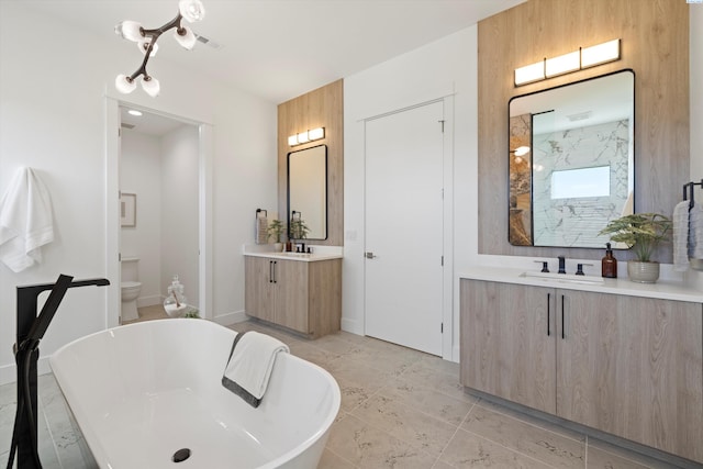 bathroom with vanity, a washtub, and toilet