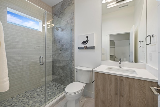 bathroom featuring vanity, toilet, and an enclosed shower