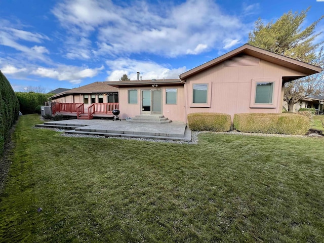 rear view of house featuring a deck and a lawn