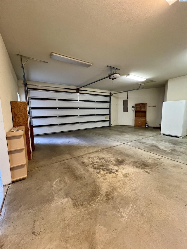 garage with white refrigerator, a garage door opener, and electric panel